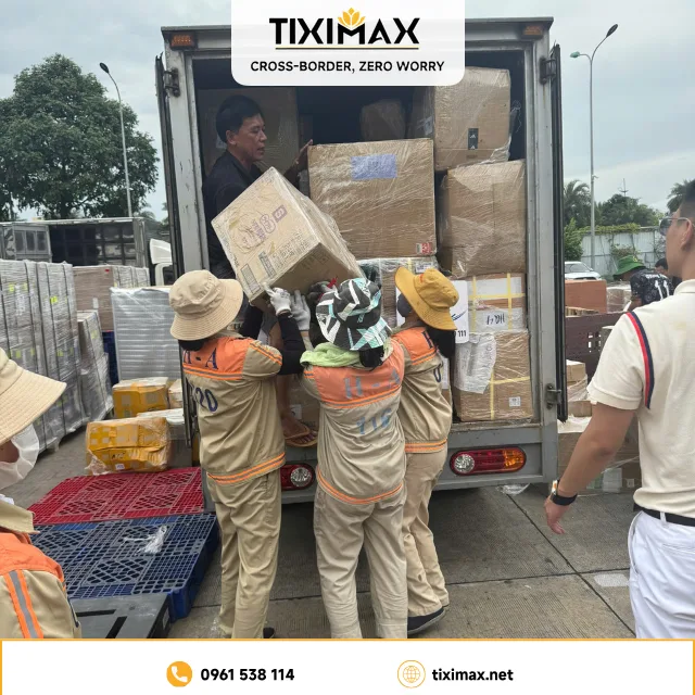 Nhân viên bốc dỡ nhiều thùng hàng từ xe tải.